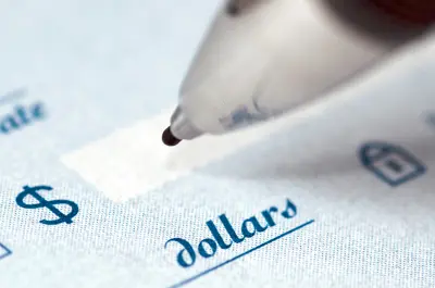 pen holding just above the dollar amount field of a bank check