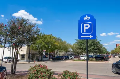 view down Main Street filled with parked vehicles behind a blue Bryan parking sign.