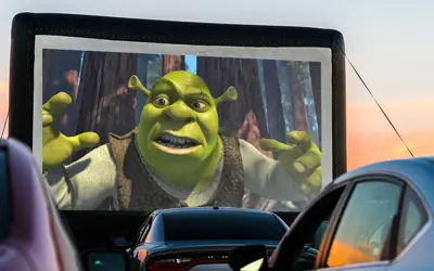 outdoor drive-up theater screen with Shrek projection
