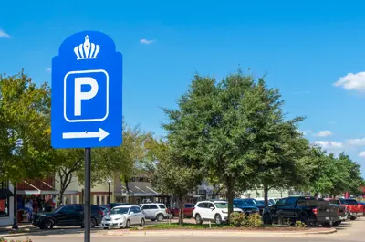 View of Main Street in Downtown Bryan with cars parked behind a "Parking" street sign