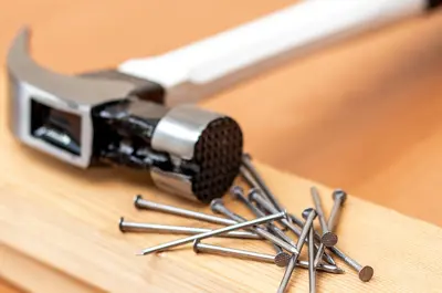 hammer and nails laying on lumber