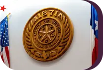 wooden plaque of the City of Bryan seal resting between two flags