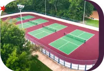 aerial view of pickleball courts next to a playground in a public park