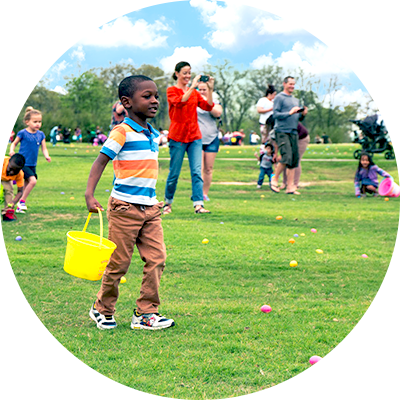 Kids run to pick up easter eggs as parents look and take pictures.