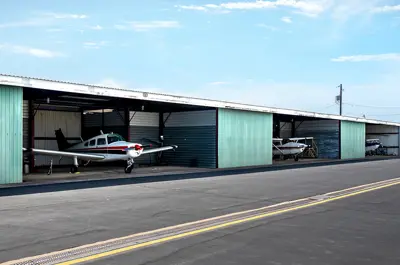 row of small hangars with aircrafts parked in each